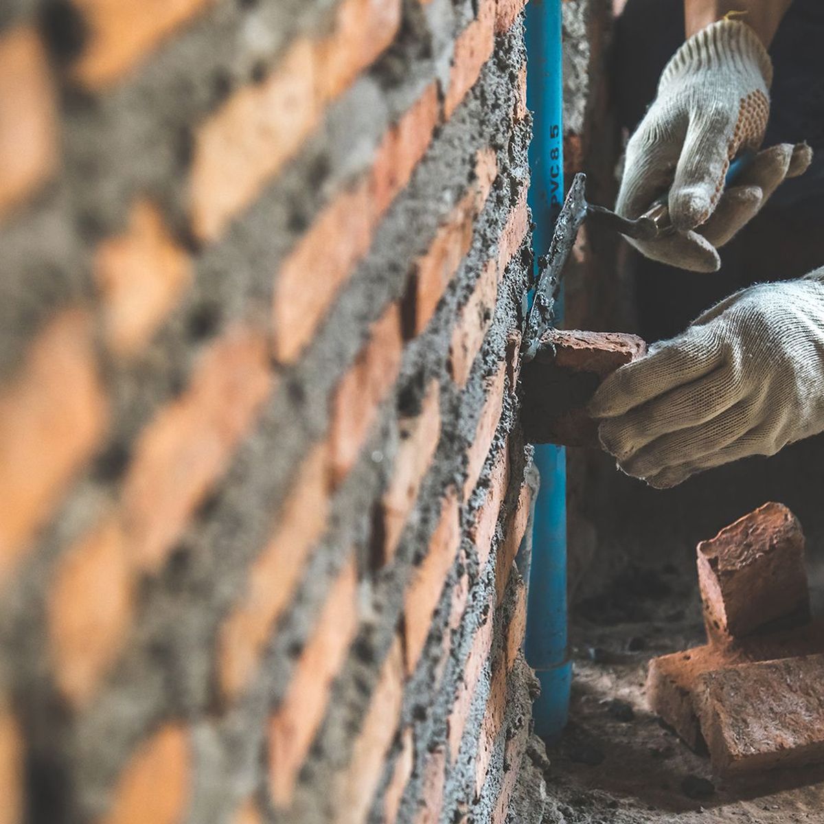 Handwerker arbeitet an einer Mauer